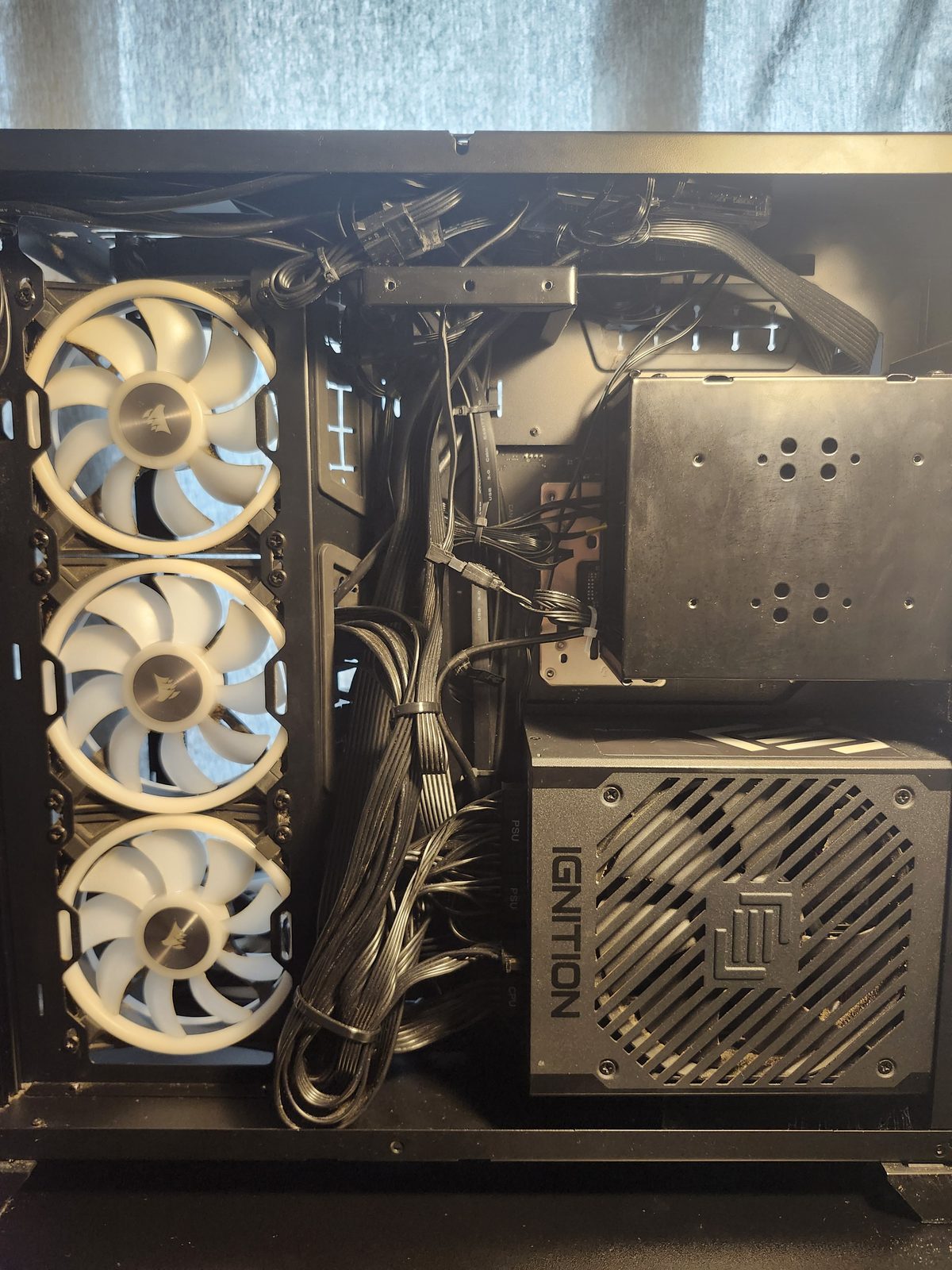 Closer view of that back-chamber cable bundle, with the white Corsair fans and the Ignition power supply.